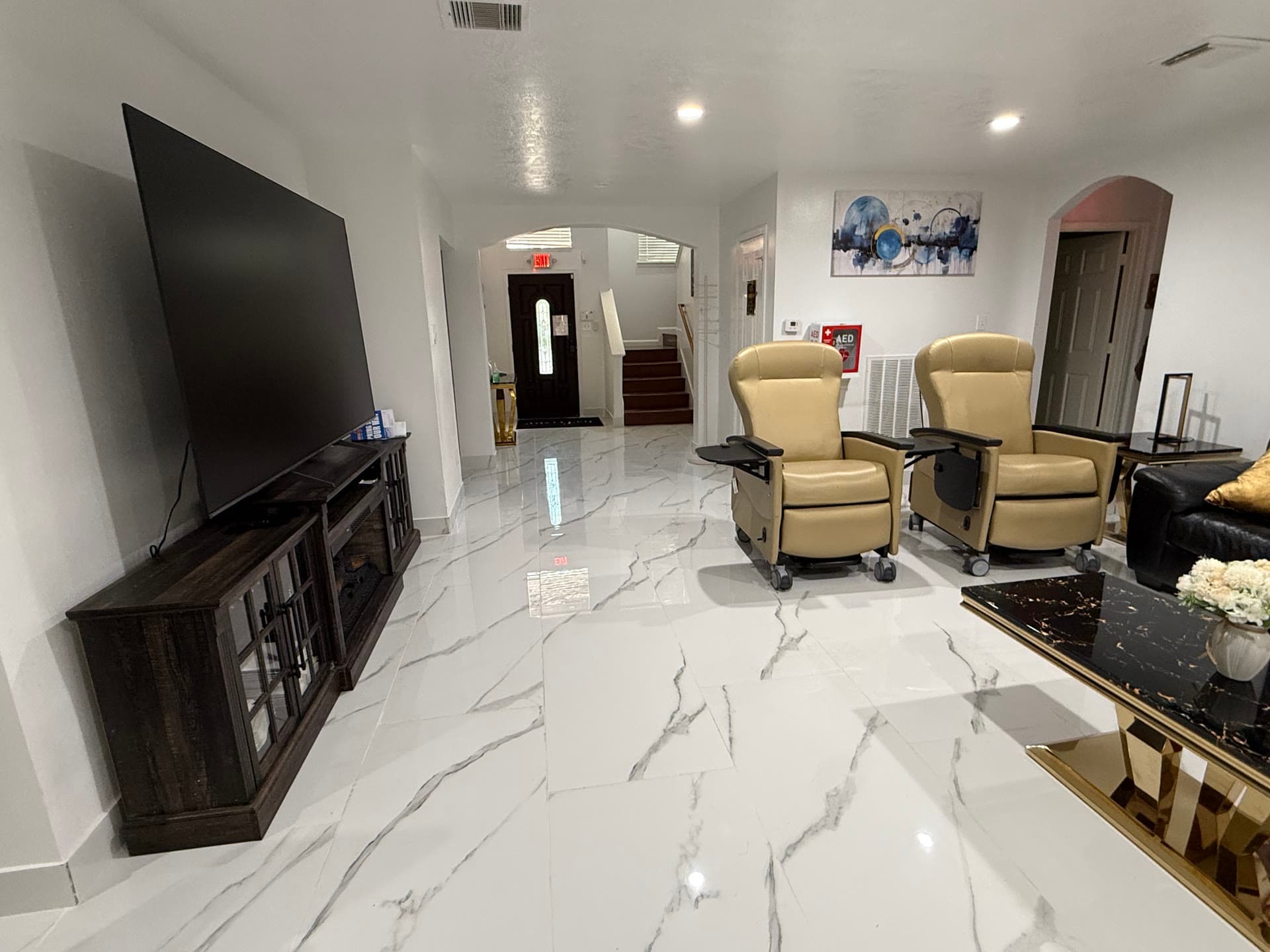 Living room with large TV, entertainment center, and comfortable recliners