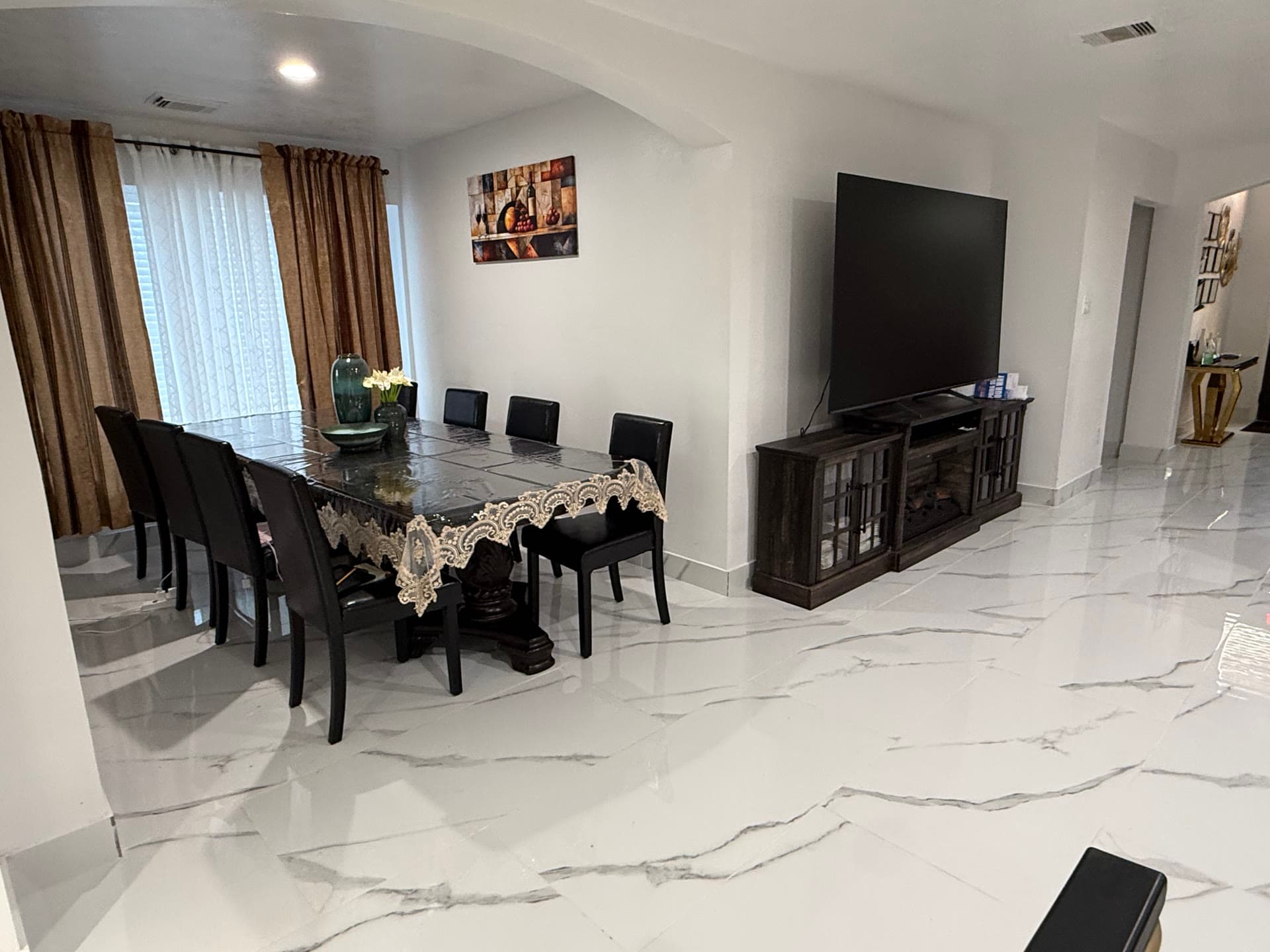 Open living and dining area with marble floors and archway