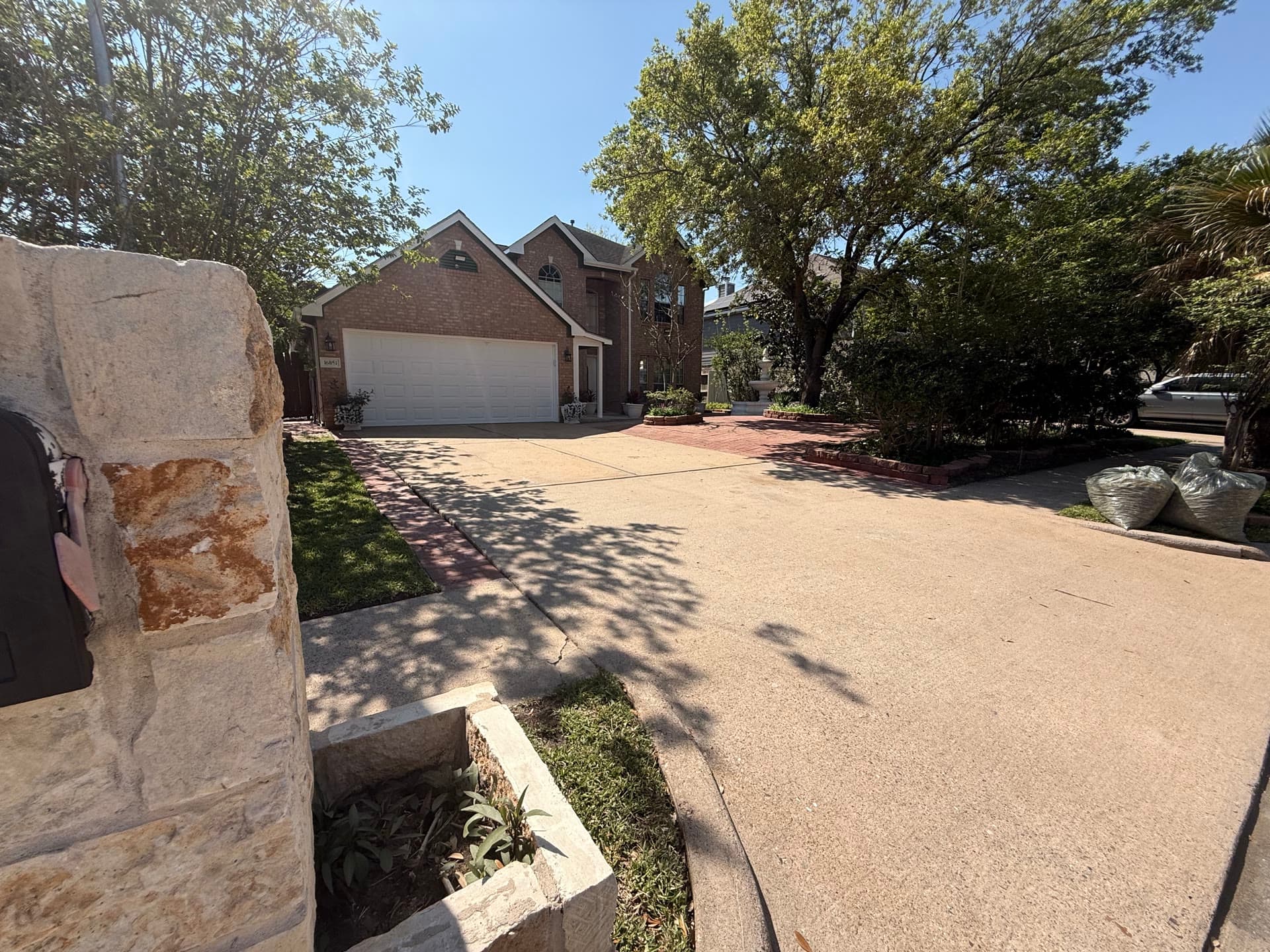 Driveway approach with stone pillars and mature trees